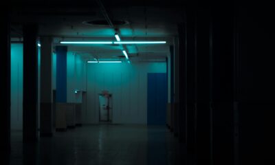 Shadowy abandoned room with a camera in the foreground, evoking a viral TikTok found-footage horror aesthetic.