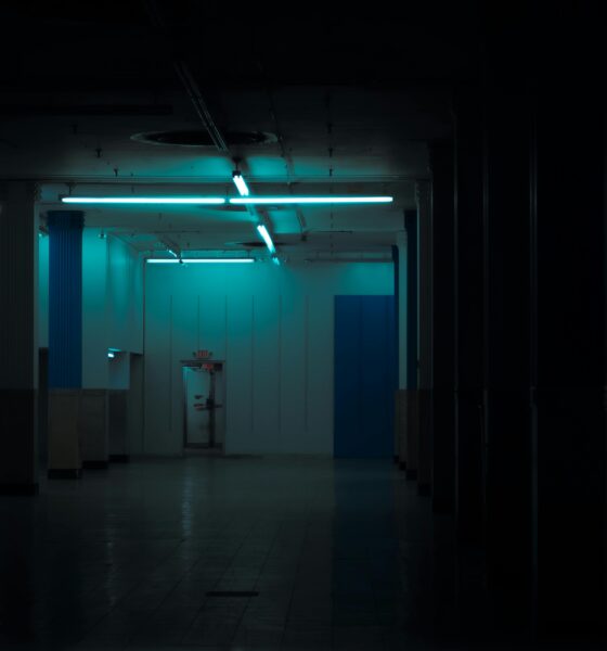 Shadowy abandoned room with a camera in the foreground, evoking a viral TikTok found-footage horror aesthetic.